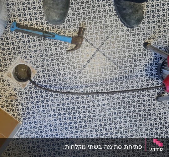 כלי עבודה של אינסטלטור על רצפה עם אריחים